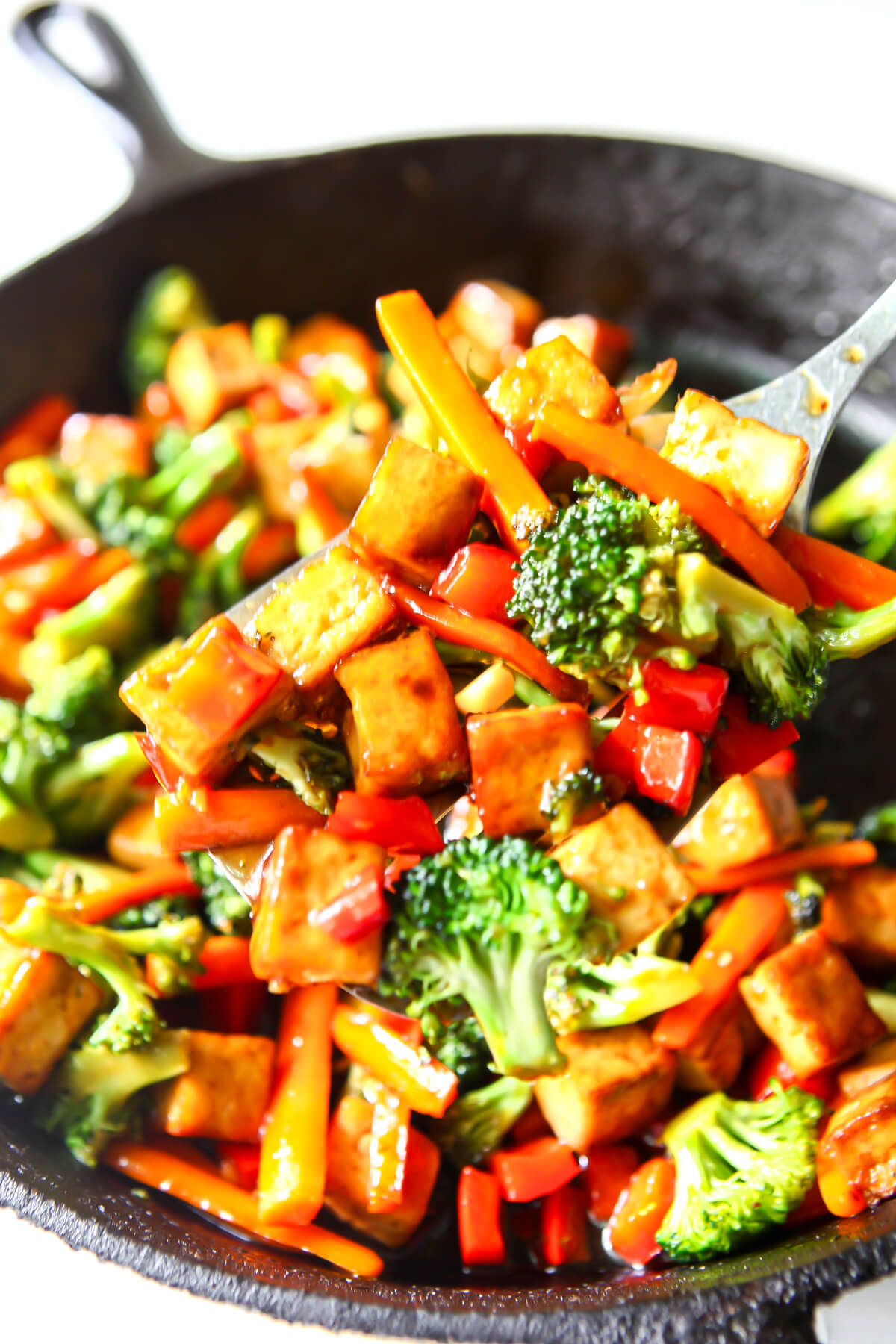 Teriyaki tofu with stir-fried vegetables in an iron skillet.