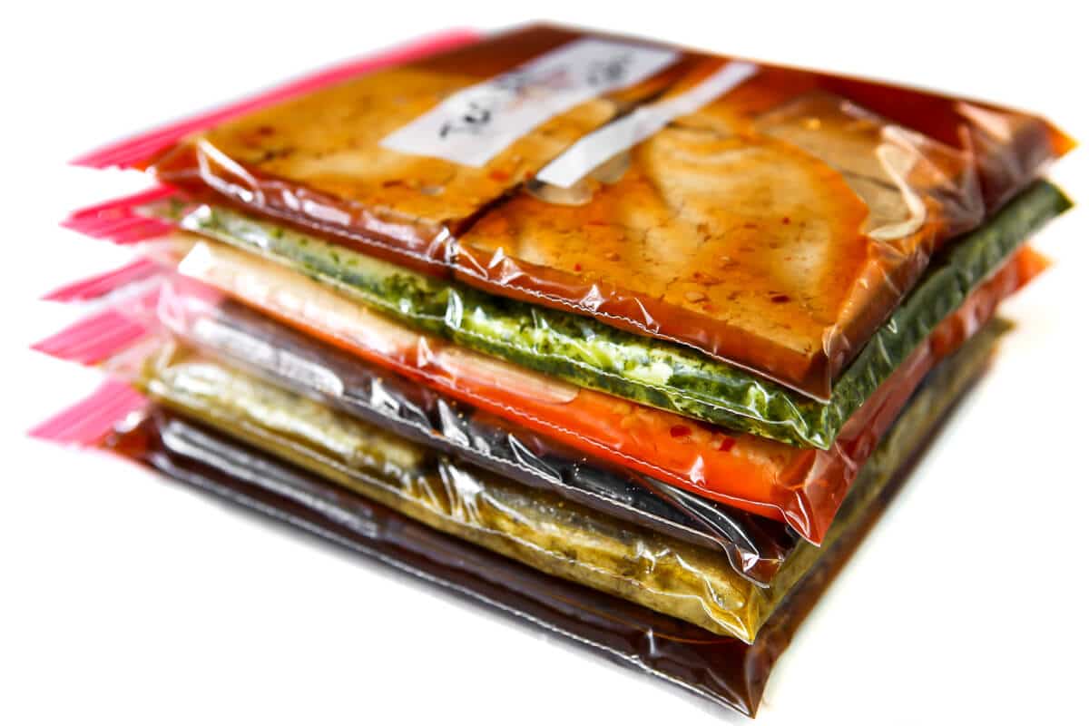 A stack of 6 bags of tofu marinades with tofu inside them.