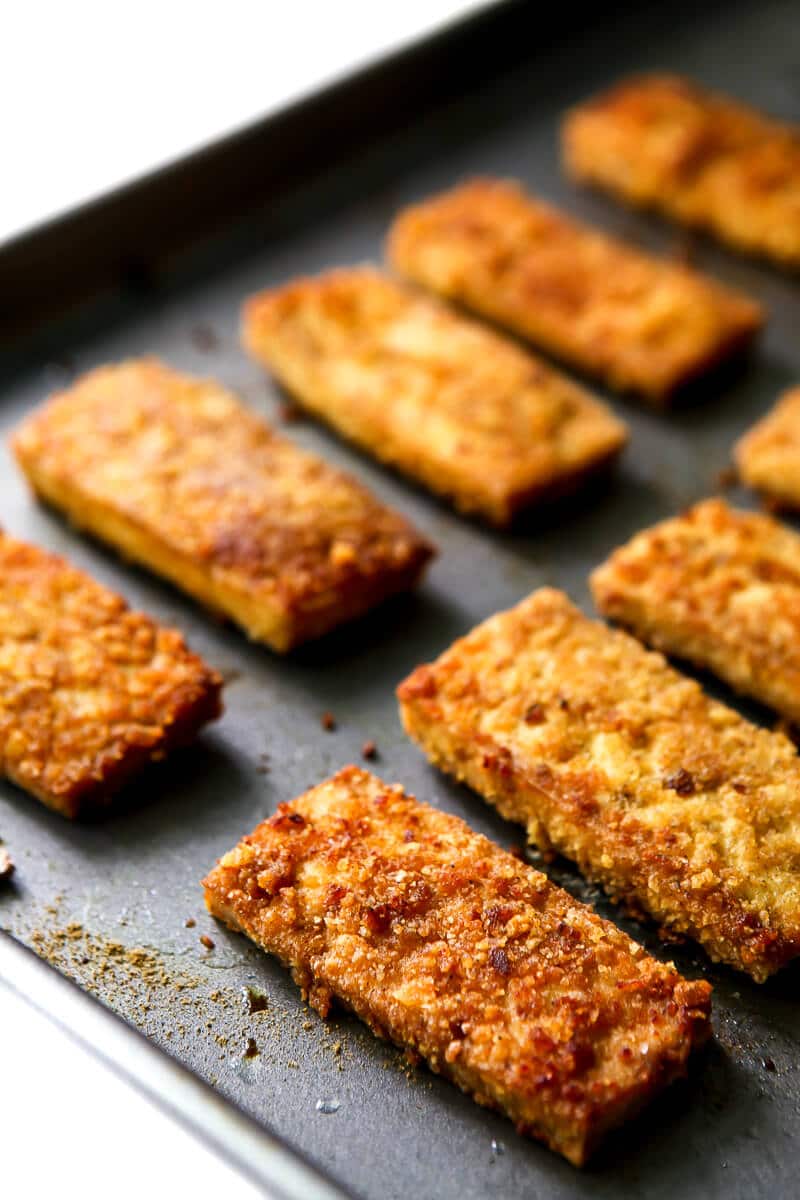Baked breaded tofu slices on a cookie sheet.