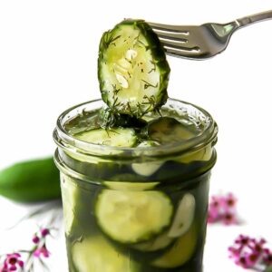 A fork taking out a refrigerator pickle from a jar.