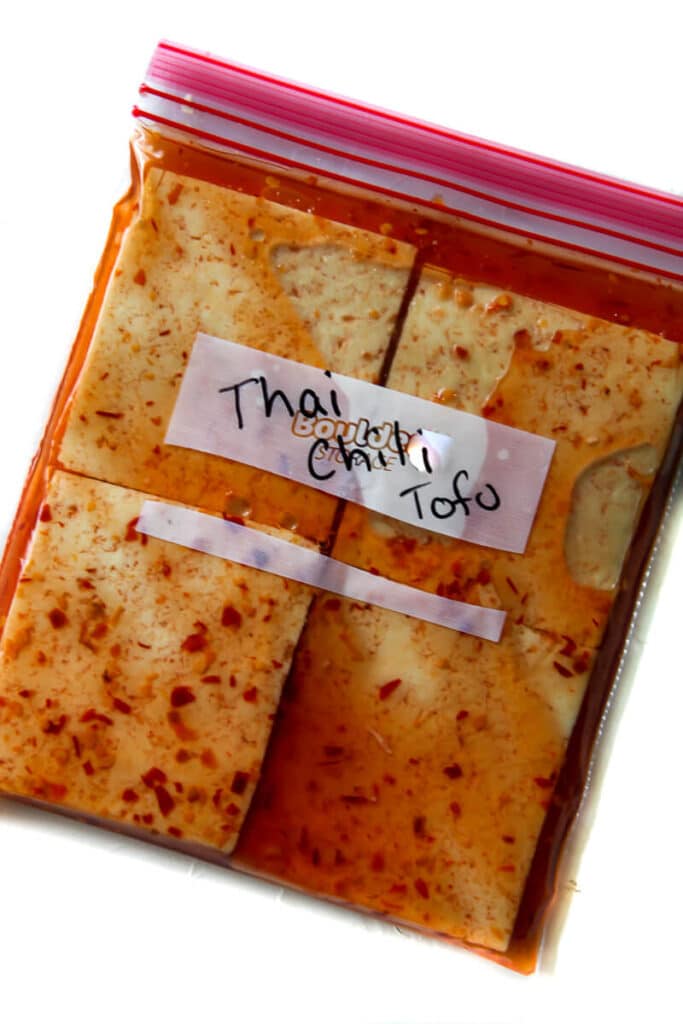 A zip lock bag filled with tofu in a Thai chili tofu marinade.