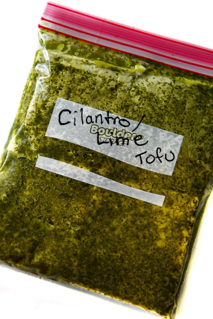 A zip lock bag filled with tofu in a cilantro lime tofu marinade.