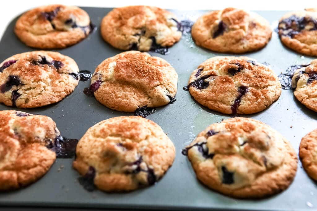 A tin full of a dozen gluten-free vegan blueberry muffins after being baked.