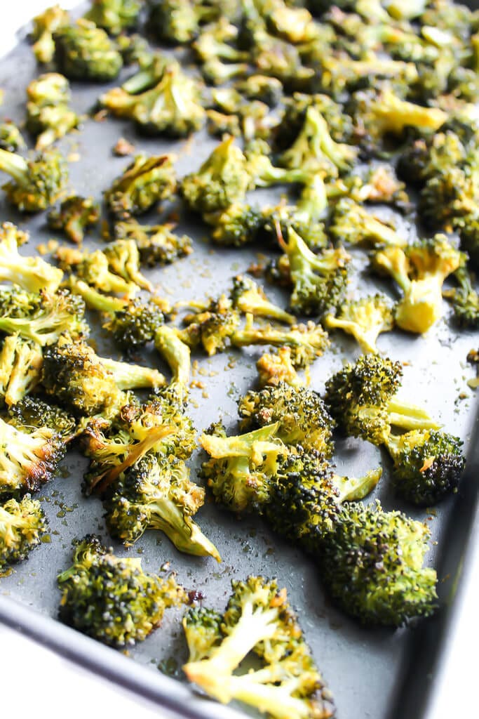 A sheet pan with vegan cheesy baked broccoli on it.
