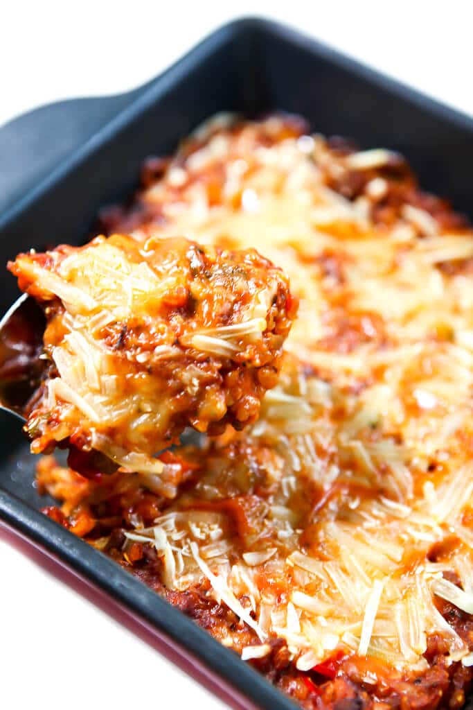 A vegan stuffed pepper casserole with a spoonful being scooped out of it.