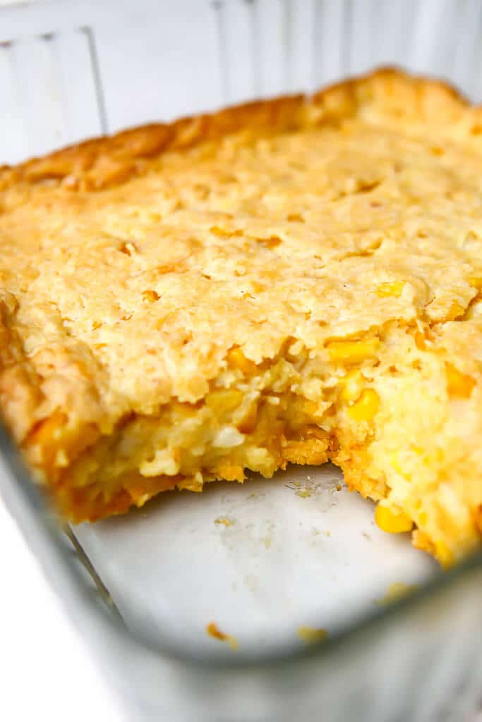 A vegan corn casserole with a piece taken out of it.