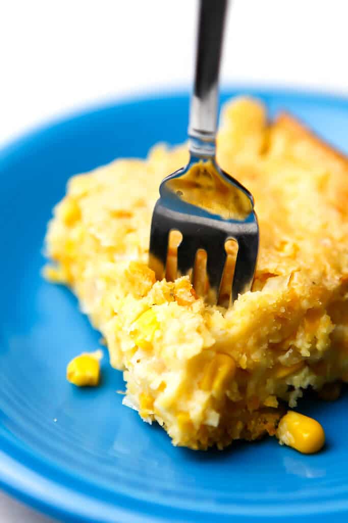 A piece of vegan corn bread casserole with a fork sticking in it.