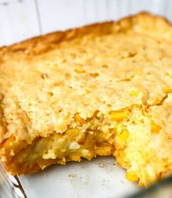 A vegan cornbread casserole with a piece taken out of it.