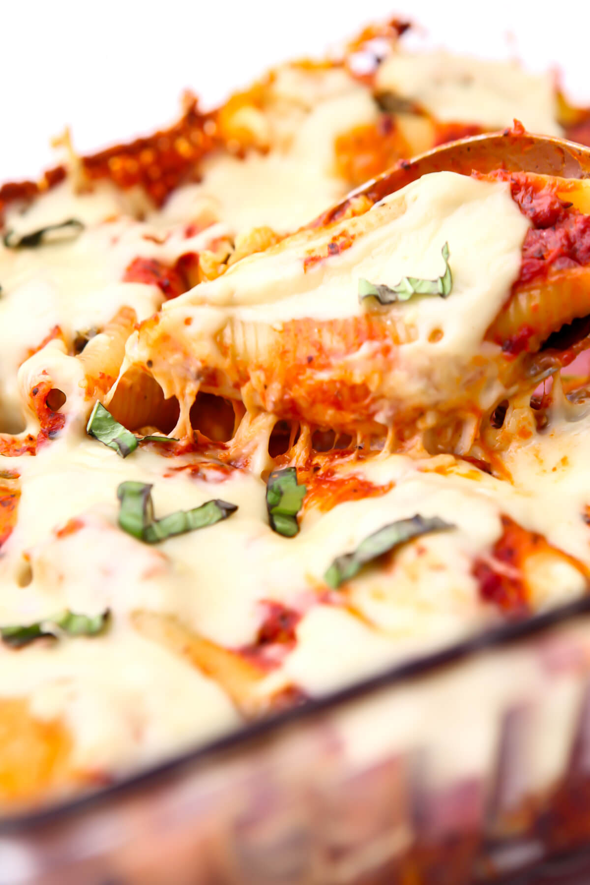 Stuffed shells topped with vegan cheese that is melted and stretchy on top.