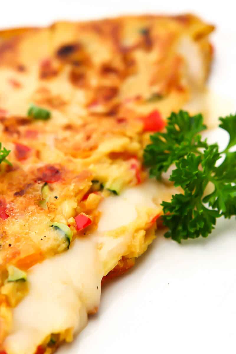 A close up of a vegan omelet filled with vegan cheese.