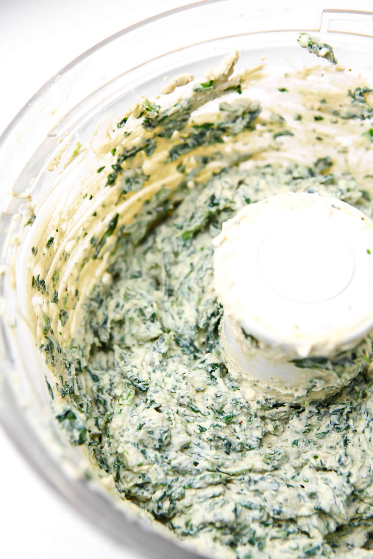 Vegan tofu ricotta in a food processor with spinach added to it.