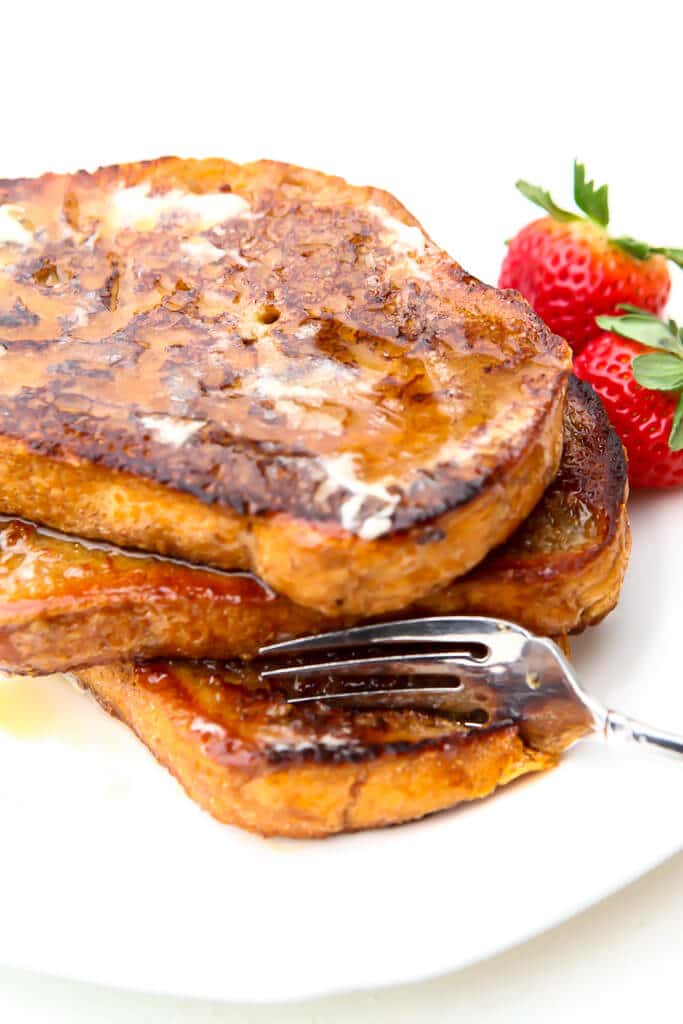 A stack of vegan French toast with a fork breaking off a piece.