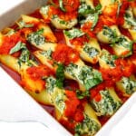 A baking dish filled with vegan stuffed shells made with tofu ricotta and spinach.