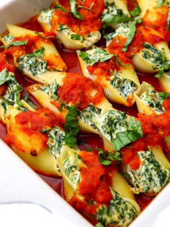 A baking dish filled with vegan stuffed shells made with tofu ricotta and spinach.