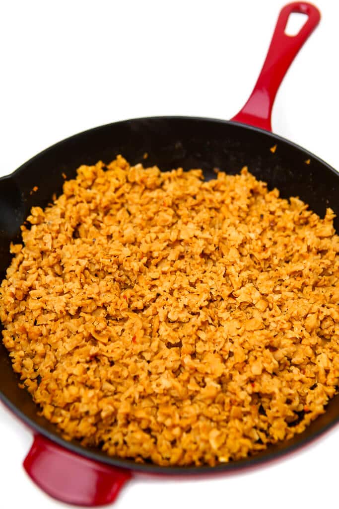 A red skillet filled with vegan taco meat made with TVP.