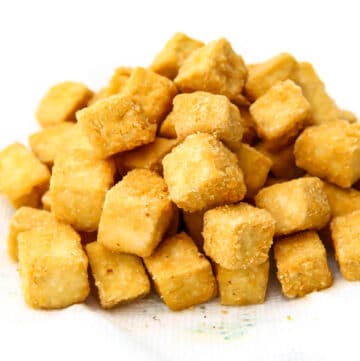 Crispy deep fried tofu cubes on a paper towel.