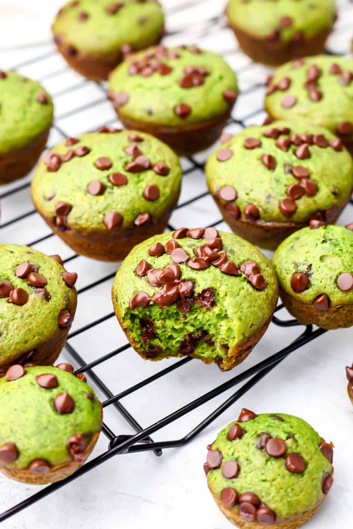 Vegan spinach muffins with chocolate chips cooling on a wire wrack.