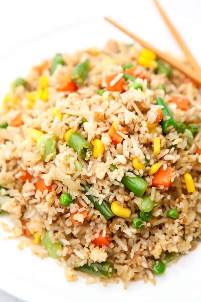 Vegan fried rice made with frozen mixed veggies on a white plate.