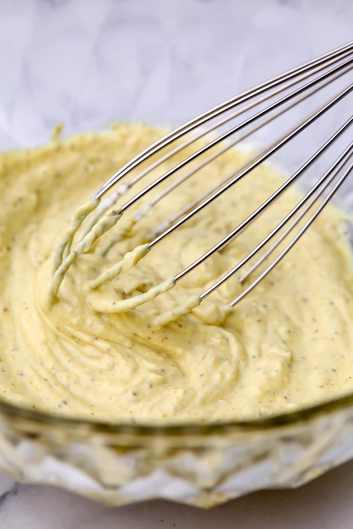 The dressing for a vegan potato salad mixing in a bowl.