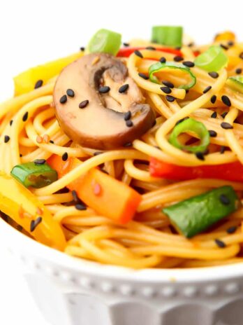 A bowl full of noodles and stir fried vegetables covered in teriyaki sauce.
