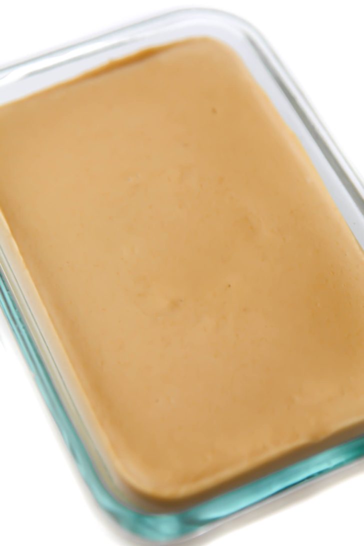 The vegan cheese in the glass container after it has set.