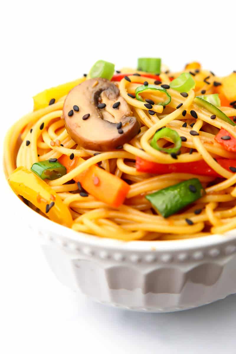 A white bowl filled with teriyaki noodles and vegetables.