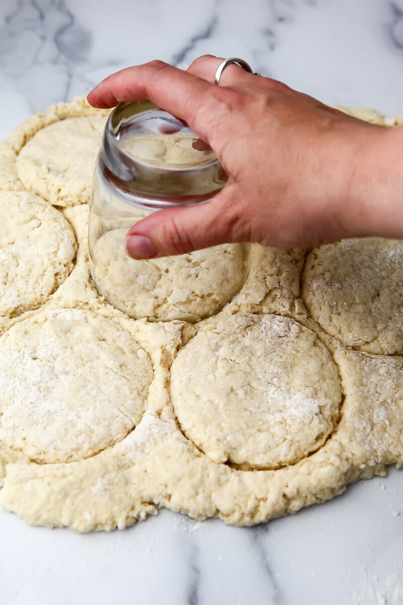Vegan shortbread on a marble cutting board being cut into biscuits for strawberry shortcake.