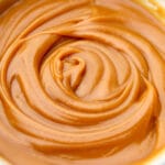 A close up of vegan peanut butter caramel dip swirled in a bowl.
