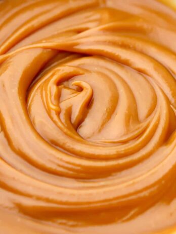 A close up of vegan peanut butter caramel dip swirled in a bowl.