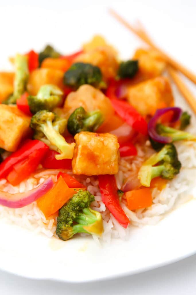 Sweet and sour tofu with pineapple, bell pepper, and broccoli over a bed of white rice.