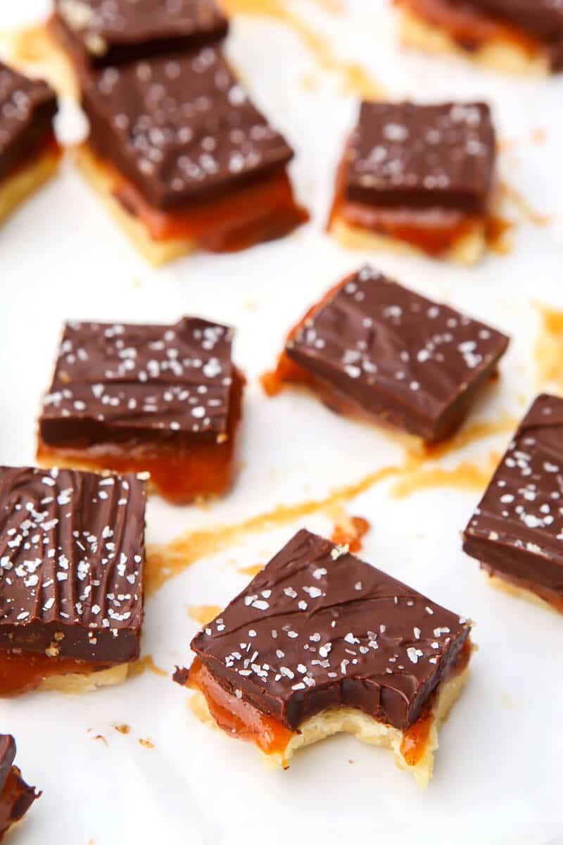 A top view of vegan millionaire shortbread bars made with shortbread, caramel, and chocolate with coarse salt sprinkled on top.