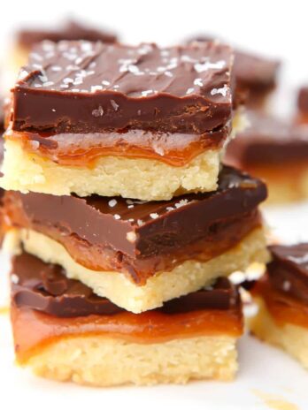 Three vegan millionaire shortbread bars stacked on top of each other.