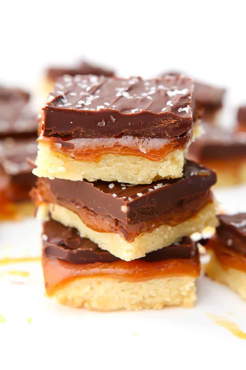 Three vegan millionaire shortbread bars stacked on top of each other.
