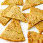 A close up of chickpea flour flat bread wedges know as Socca or Farinata.