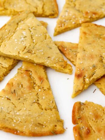 A close up of chickpea flour flat bread wedges know as Socca or Farinata.