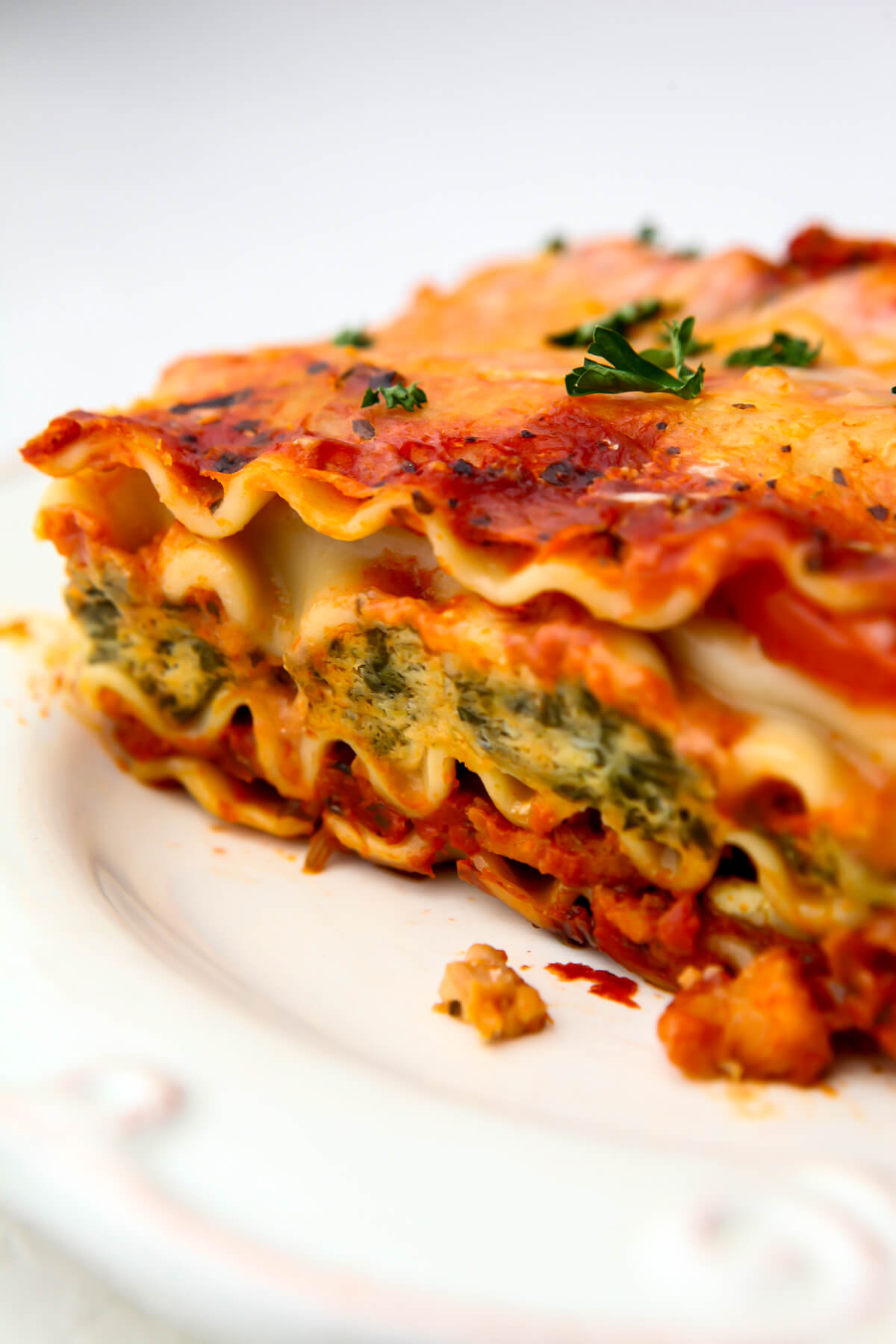 A close up of a piece of 12 layer vegan lasagna with tofu spinach ricotta and TVP sausage.
