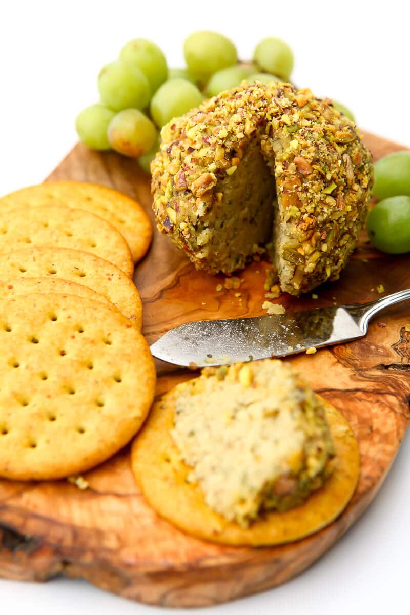 A vegan cheese ball made from almond flour and rolled in crushed pistachio nuts.