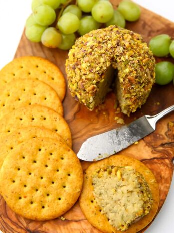 Almond cheese formed into a cheese ball and rolled in crushed pistachio nuts with crackers on the side.