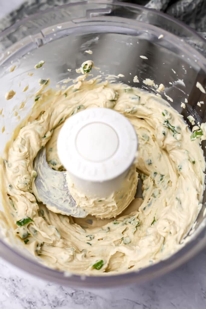 Vegan cream cheese with garlic and herbs blended into it in a food processor.