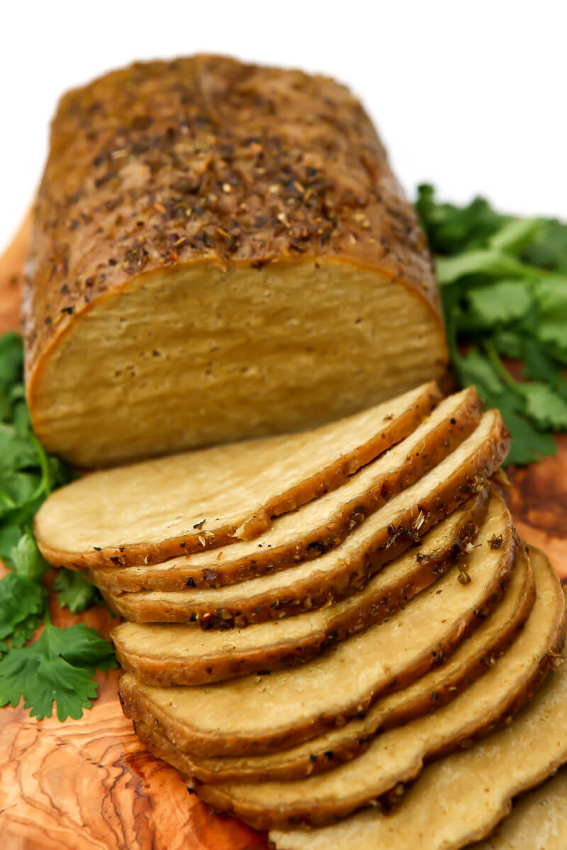 A sliced tofu and seitan turkey on a cutting board.