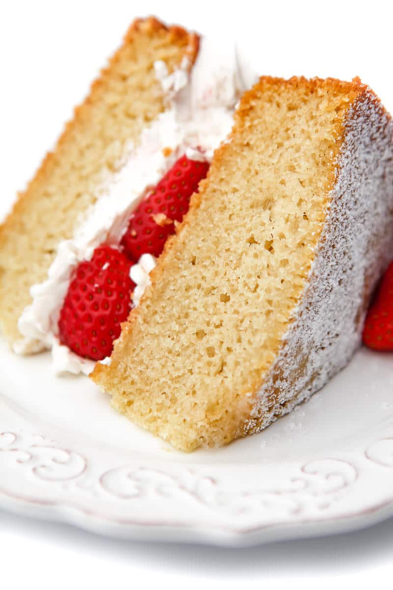 A slice of egg-free sponge cake with strawberries and cream between the layers.