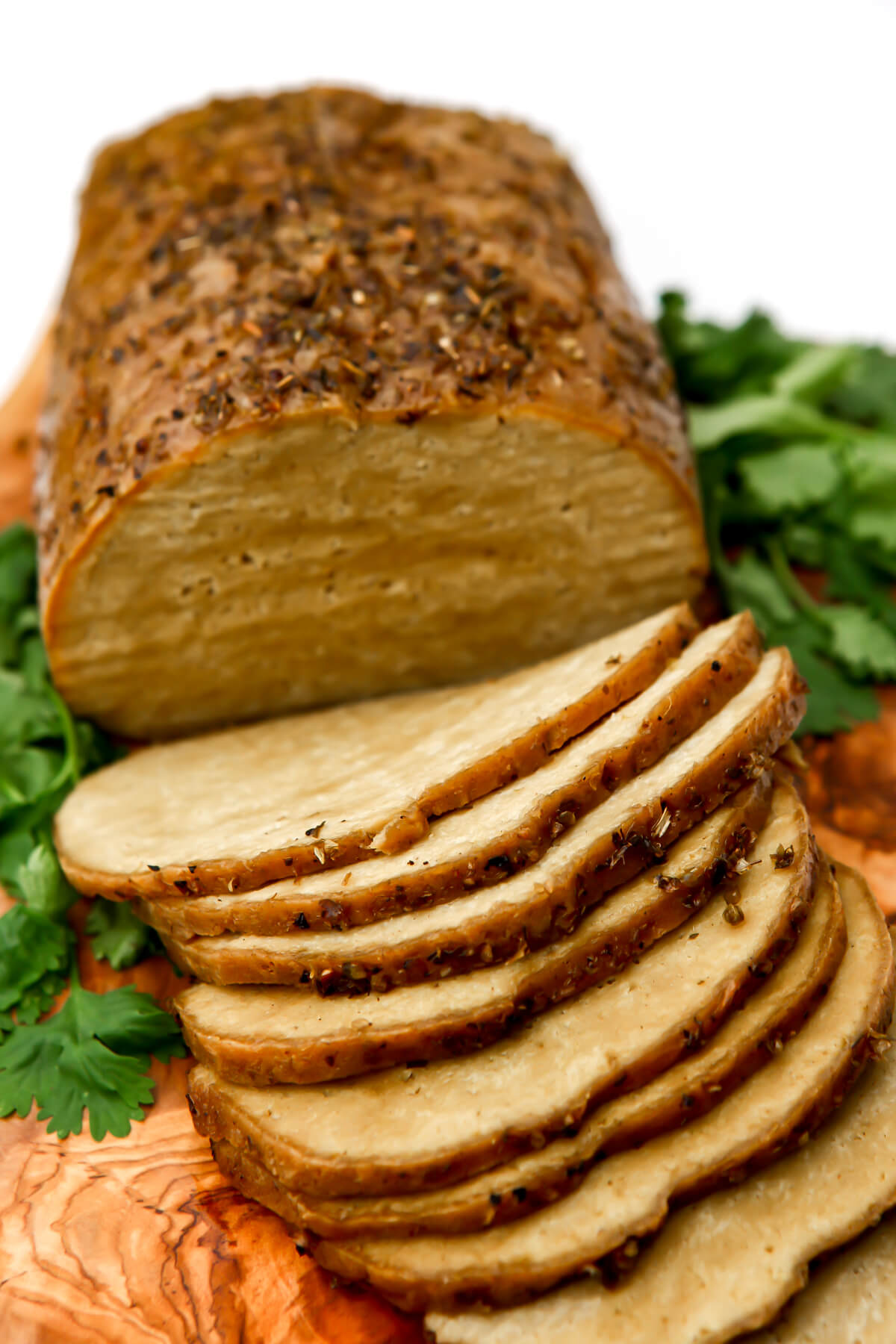 A sliced tofu and seitan turkey on a cutting board.