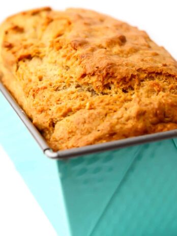 A loaf of vegan banana bread in a bright blue bread pan.