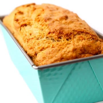 A loaf of vegan banana bread in a bright blue bread pan.