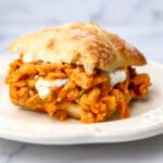 A vegan buffalo chicken sandwich made with soy curls and vegan ranch served on a bun.