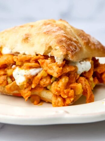 A vegan buffalo chicken sandwich made with soy curls and vegan ranch served on a bun.