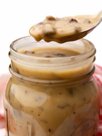 A spoonful of canned vegan cream of mushroom soup over a jar.