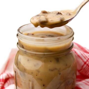 A spoonful of canned vegan cream of mushroom soup over a jar.