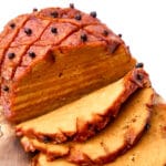A vegan ham made from seitan sliced on a cutting board.