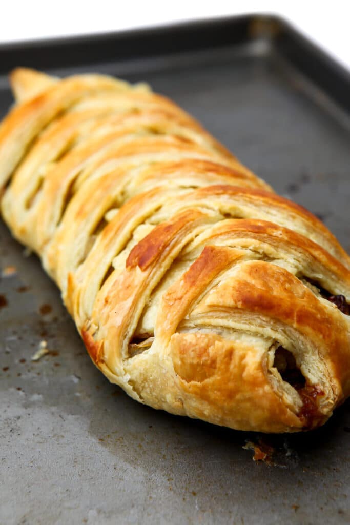 A vegan wellington on a cookie sheet golden brown after it is baked.